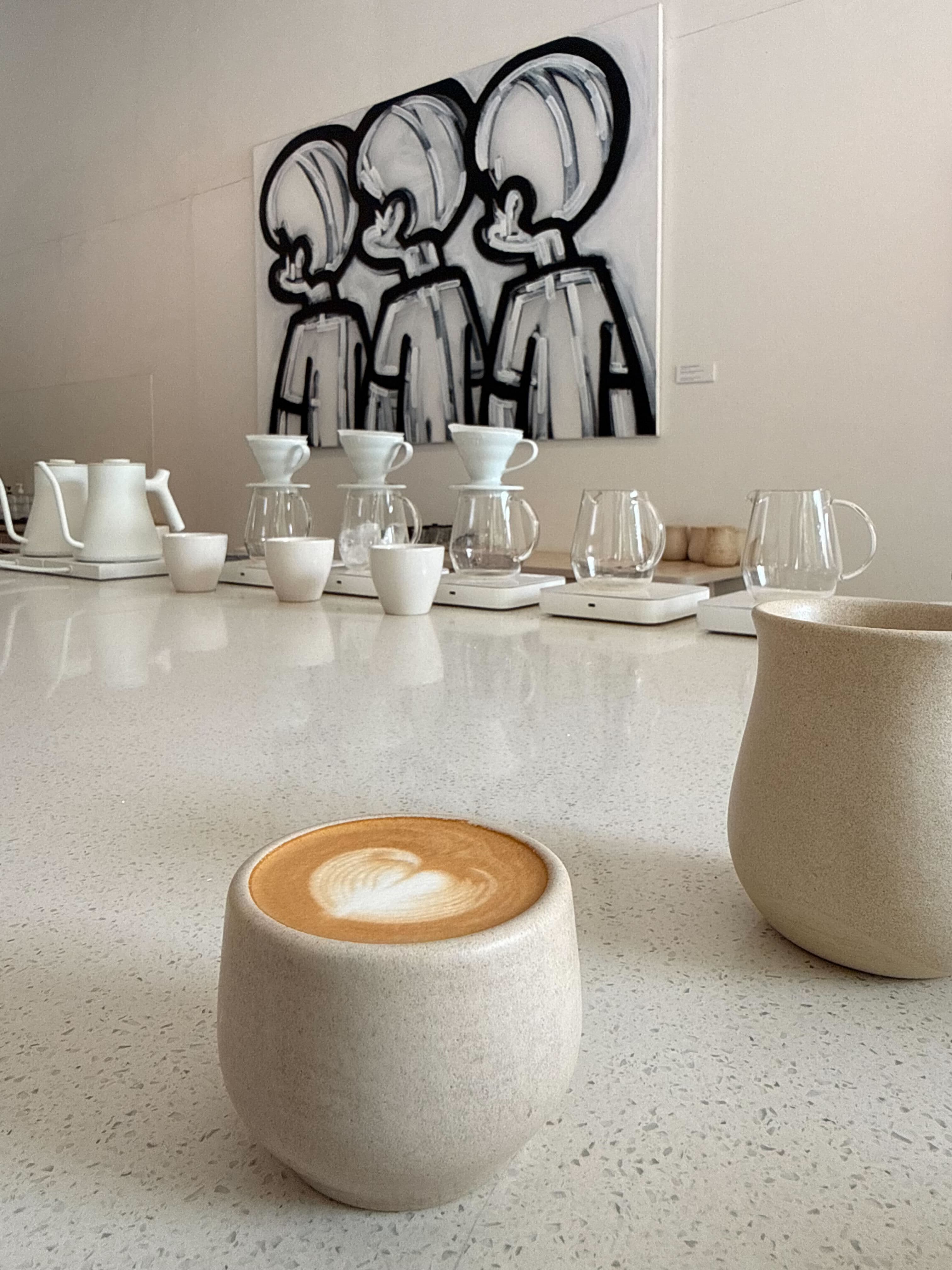 Latte art with bold illustration mural in background